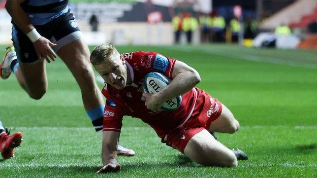 Johnny McNicholl yn sgorio dau gais i'r Scarlets a hynny ar ei 100fed ymddangosiad