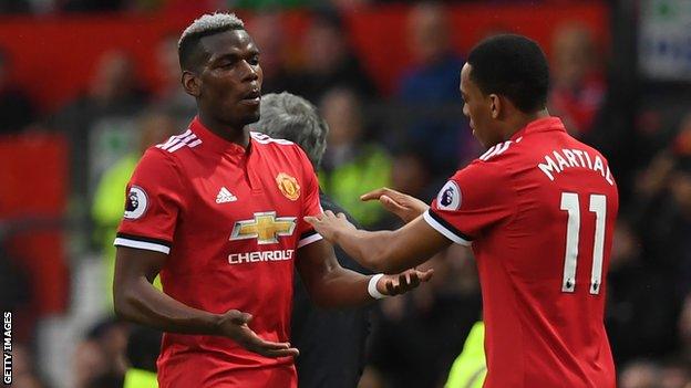 Manchester United midfielder Paul Pogba taps hands with Anthony Martial as he is replaced