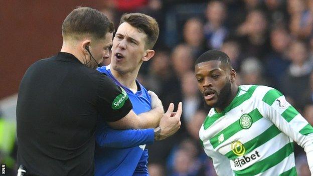 Referee John Beaton has to restrain Rangers midfielder during the recent Old Firm game