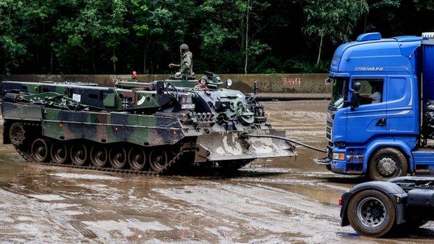 Army soldiers tow a truck stuck in floodwaters