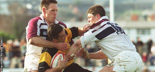 Newport's Franco Smith is tackled by Mark Taylor and Scott Gibbs of Swansea