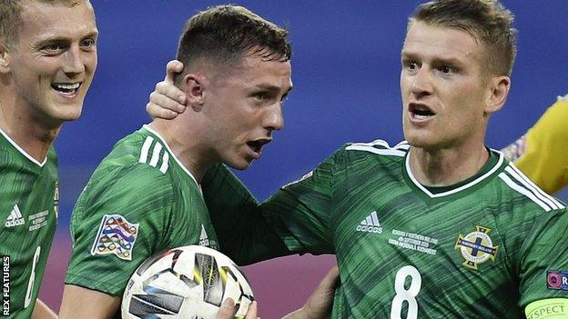 Gavin Whyte is mobbed by Northern Ireland teammates after scoring against Romania