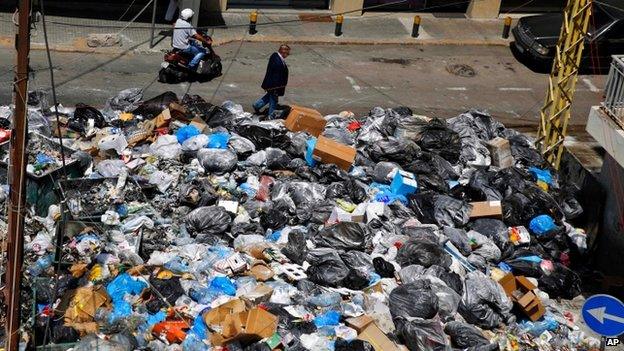 Man walks past masses of rubbish in Beirut street