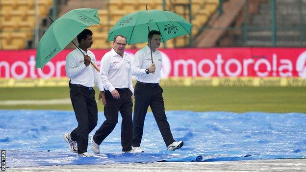 The umpires shelter from the rain in Bangalore