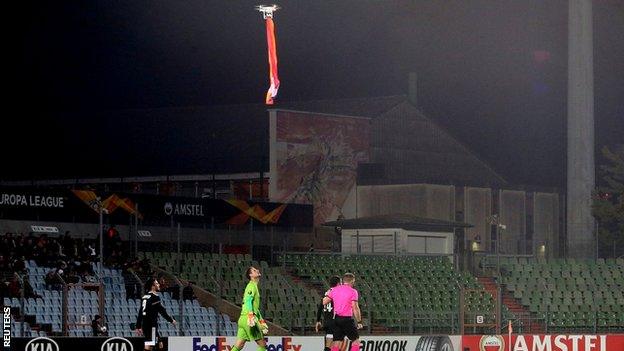 A flag hangs from a drone