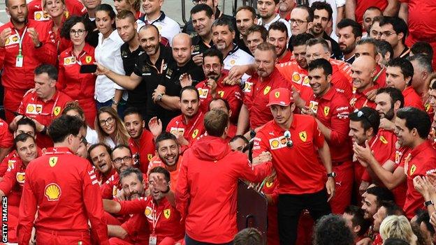 Charles Leclerc and Sebastian Vettel shake hands in front of the Ferrari crew at Monza