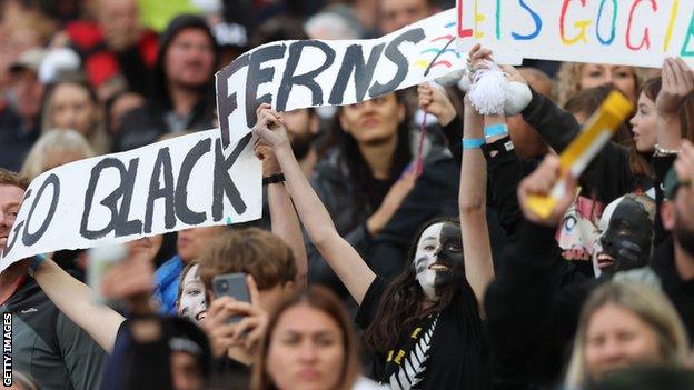 New Zealand fans hold up a sign reading 'Go Black Ferns'