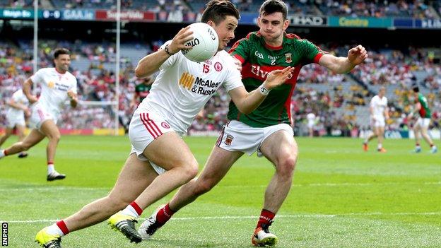 Ronan O'Neill attempts to escape the clutches of Brendan Harrison during the first half