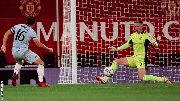 Manchester United keeper Dean Henderson makes a save in a Carabao Cup tie against West Ham