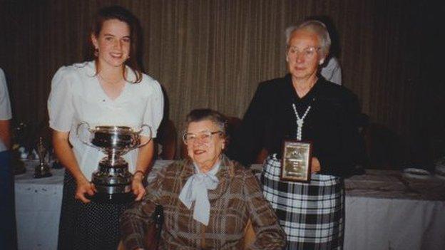 Women holding sporting trophy