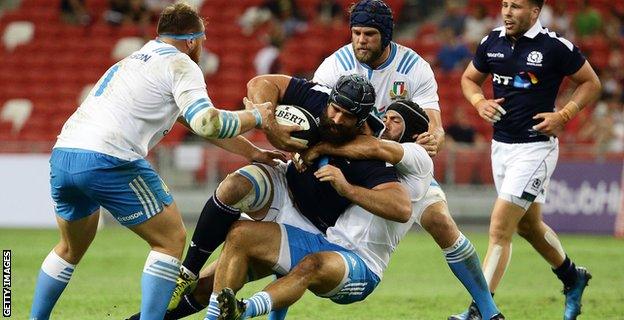 Josh Strauss draws the attention of three Italy players in Scotland's win in Singpore on 10 June