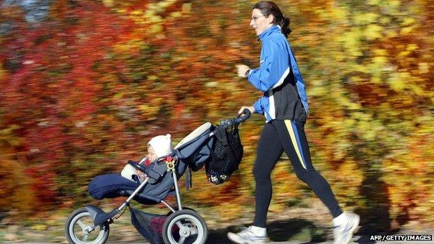 Mother jogging while pushing pram