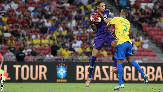 Maduka Okoye (left) catches the ball ahead of Brazil striker Richarlson