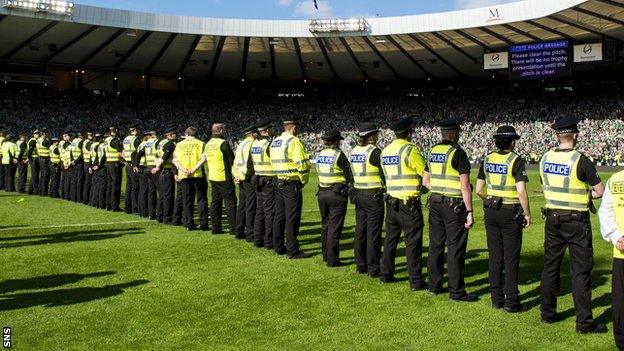 Police stand guard on the Hampden pitch