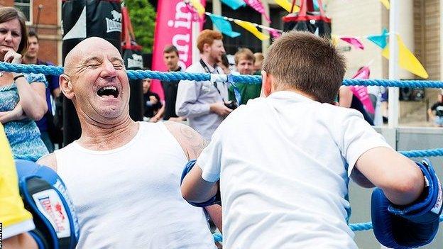 Man having fun in a boxing ring with a young boy