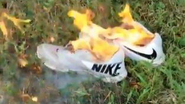 A pair of Nike trainers on fire.