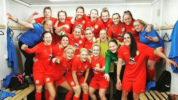 The Isle of Man women's football team celebrate in the dressing room after one of their four victories.