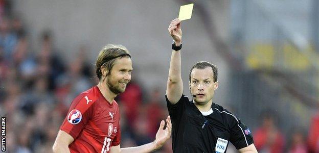 Willie Collum shows a yellow card to Czech Republic midfielder Jaroslav Plasil