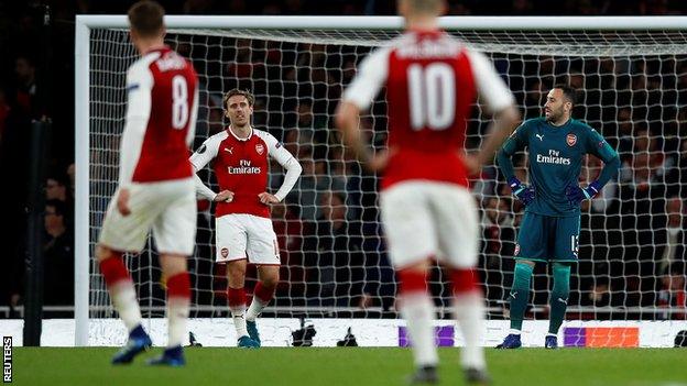 Arsenal players look on disappointed after Griezmann scores for Atletico