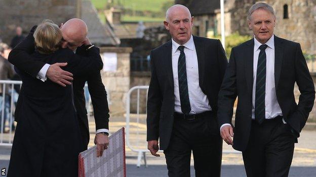 Keith Wood is embraced as Ireland coach Joe Schmidt (right) and former Ireland team manager Michael Kearney arrive at St Flannan's Church in Killaloe