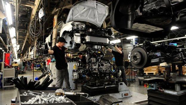 Employees working on a car assembly line