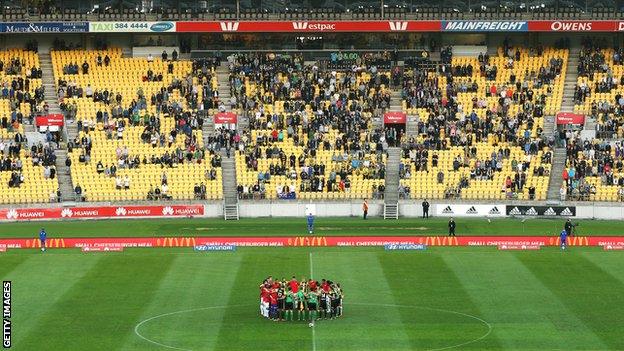 Players and officials form a huddle in support of victims of the Christchurch mosque shootings during the match between the Wellington Phoenix and the Western Sydney Wanderers at Westpac Stadium in Wellington