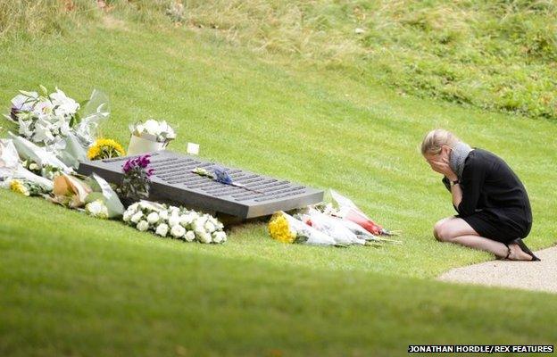 A young woman lays flowers in Hyde Park