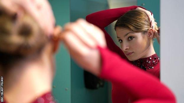 Kristen Spours fixes her hair in the mirror.