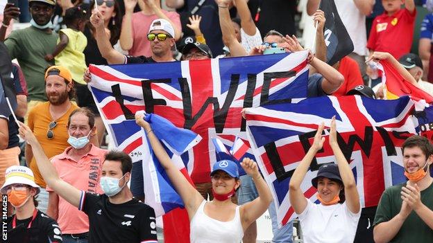 Fans at the French grand prix hold their Lewis Hamilton flags aloft