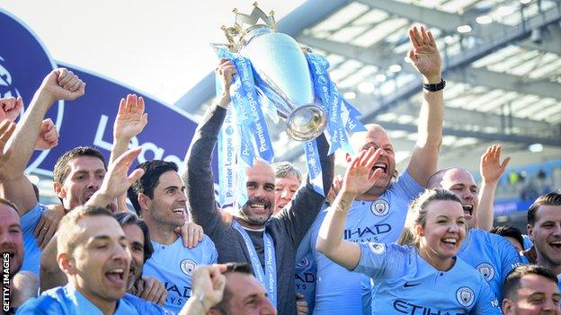 Pep Guardiola holds aloft the Premier League trophy