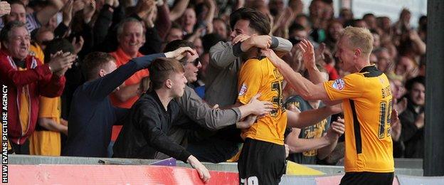 Aaron Collins celebrates a goal with the Newport fans