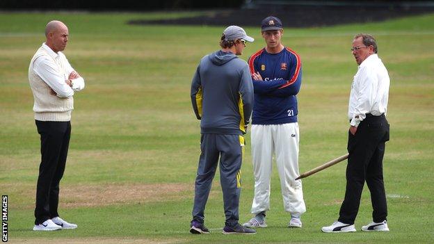 Umpires Billy Taylor and Ian Gould inspect the pitch at Arundel with a stump along with Essex captain Tom Westley and Hampshire captain Sam Northeast