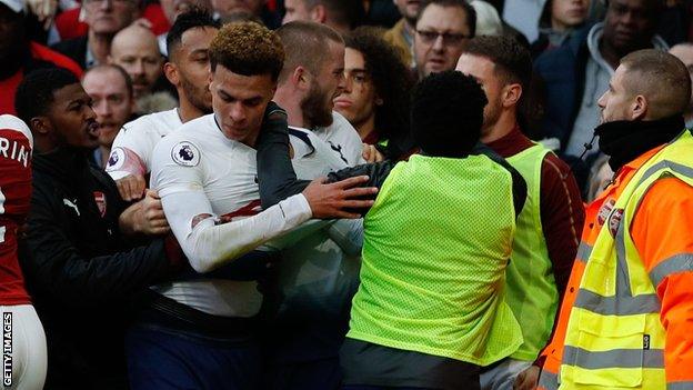 Spurs midfielder Dele Alli grapples with Arsenal substitutes