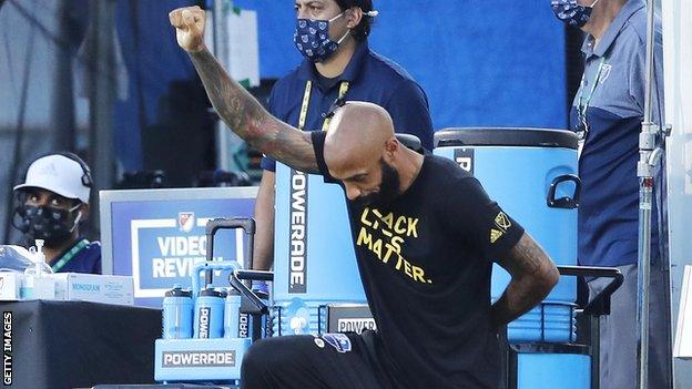 Thierry Henry takes a knee in support of the Black Lives Matter movement before CF Montreal's match with Toronto FC