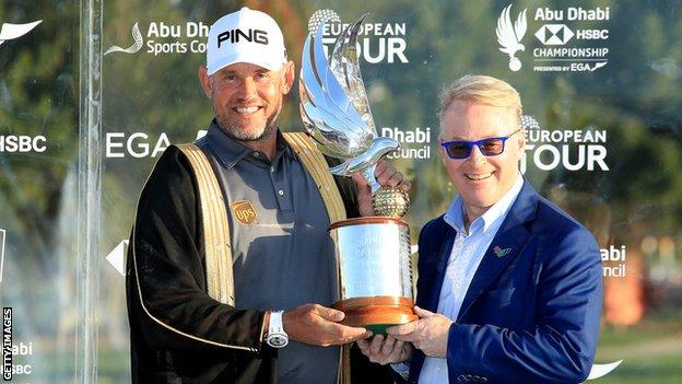 Lee Westwood accepts the Abu Dhabi Championship trophy from European Tour chief executive Keith Pelley