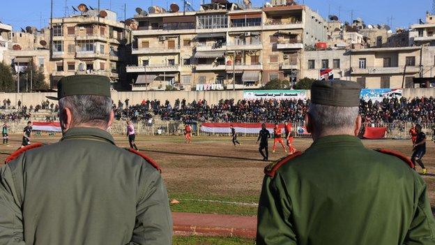 Soldiers watch a football match in Syria