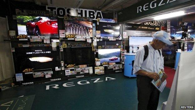 A man looks at Toshiba Regza televisions at an electronics retailer in Tokyo