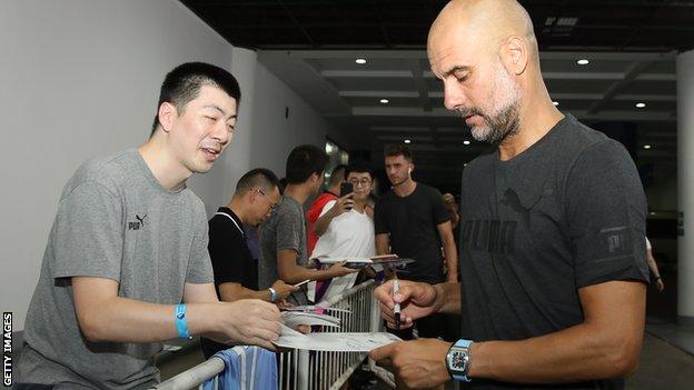 Pep Guardiola signs an autograph for a Chinese fan