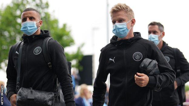 Manchester City players Kyle Walker (left) and Oleksandr Zinchenko (right) wear masks as they arrive for a Premier League match