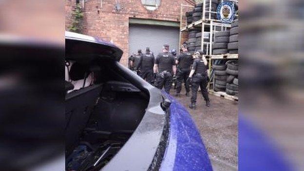 Moment before police officers raid suspected chop shop