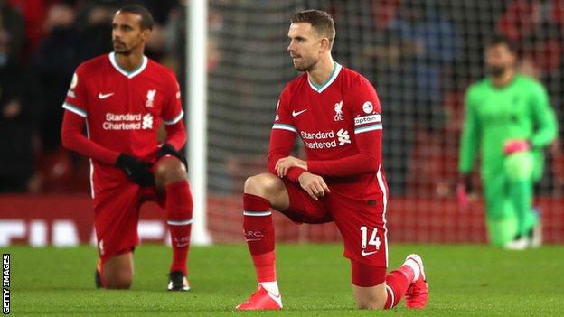 Jordan Henderson takes a knee before kick-off