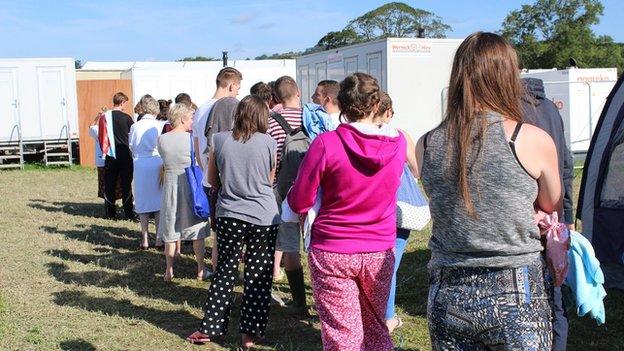 Mae dechrau'r diwrnod yn golygu ciwio am gawod ar y maes carafanau // A new day means joining the queue for the showers on the caravan park