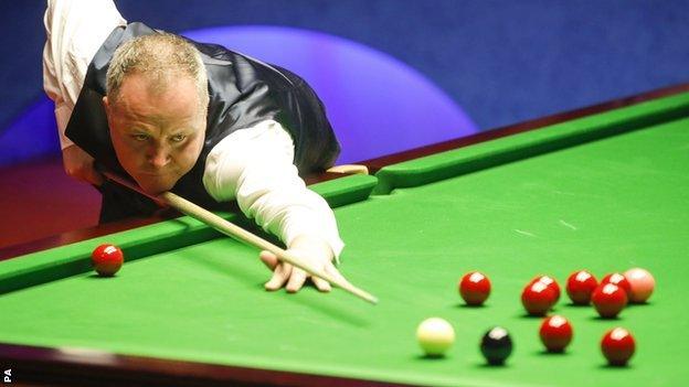 John Higgins plays a shot