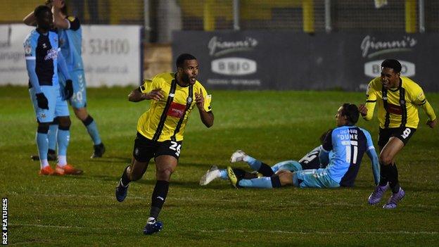 Kevin Lokko of Harrogate Town celebrates after scoring his team's fifth goal against Cambridge United