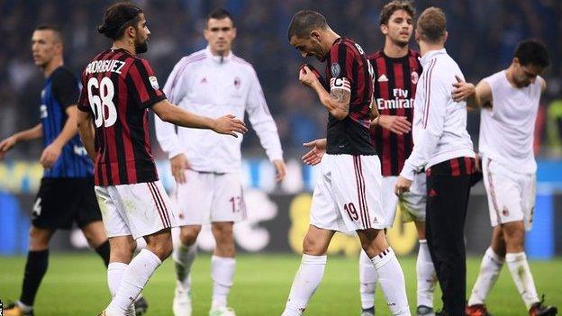 AC Milan players react at the end of their 3-2 defeat to Inter Milan