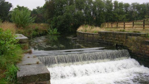 River Irk: Flood warnings in place after heavy rainfall - BBC News