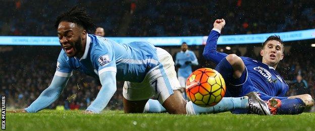 Raheem Sterling tumbles after a challenge from John Stones