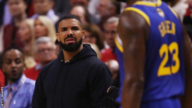 Drake looking puzzling at Draymond Green