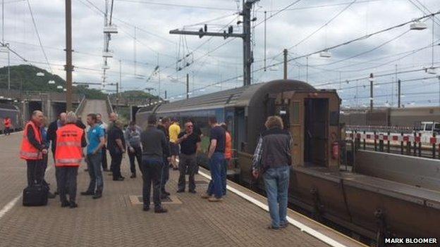 Train at a station with staff and passengers on the platform