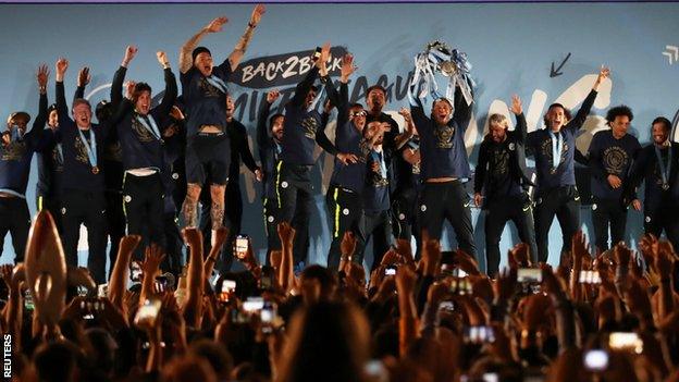 Manchester City's players emerge on stage to parade the Premier League trophy